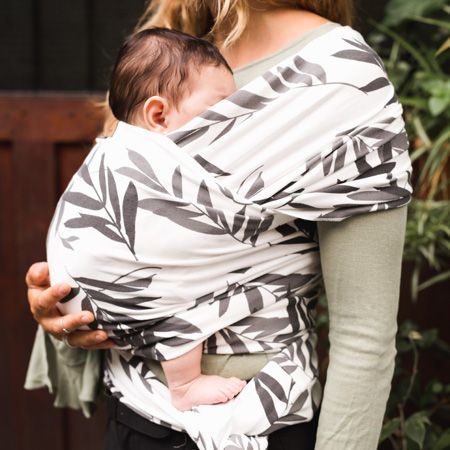 mujer porteando a bebe con fular con flores grises