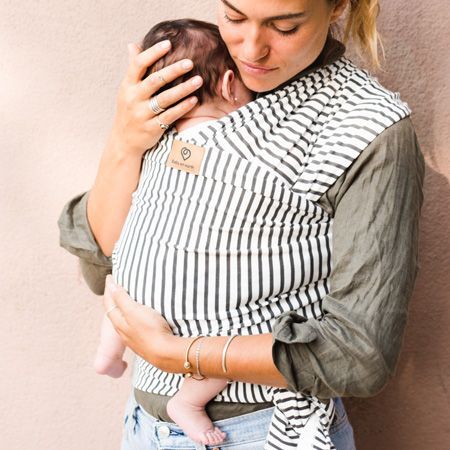mujer porteando a bebe con fular de rallas negras y blancas