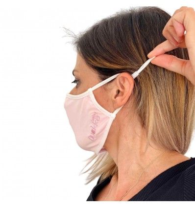 mujer con mascarilla higiénica rosa ajustable de perfil